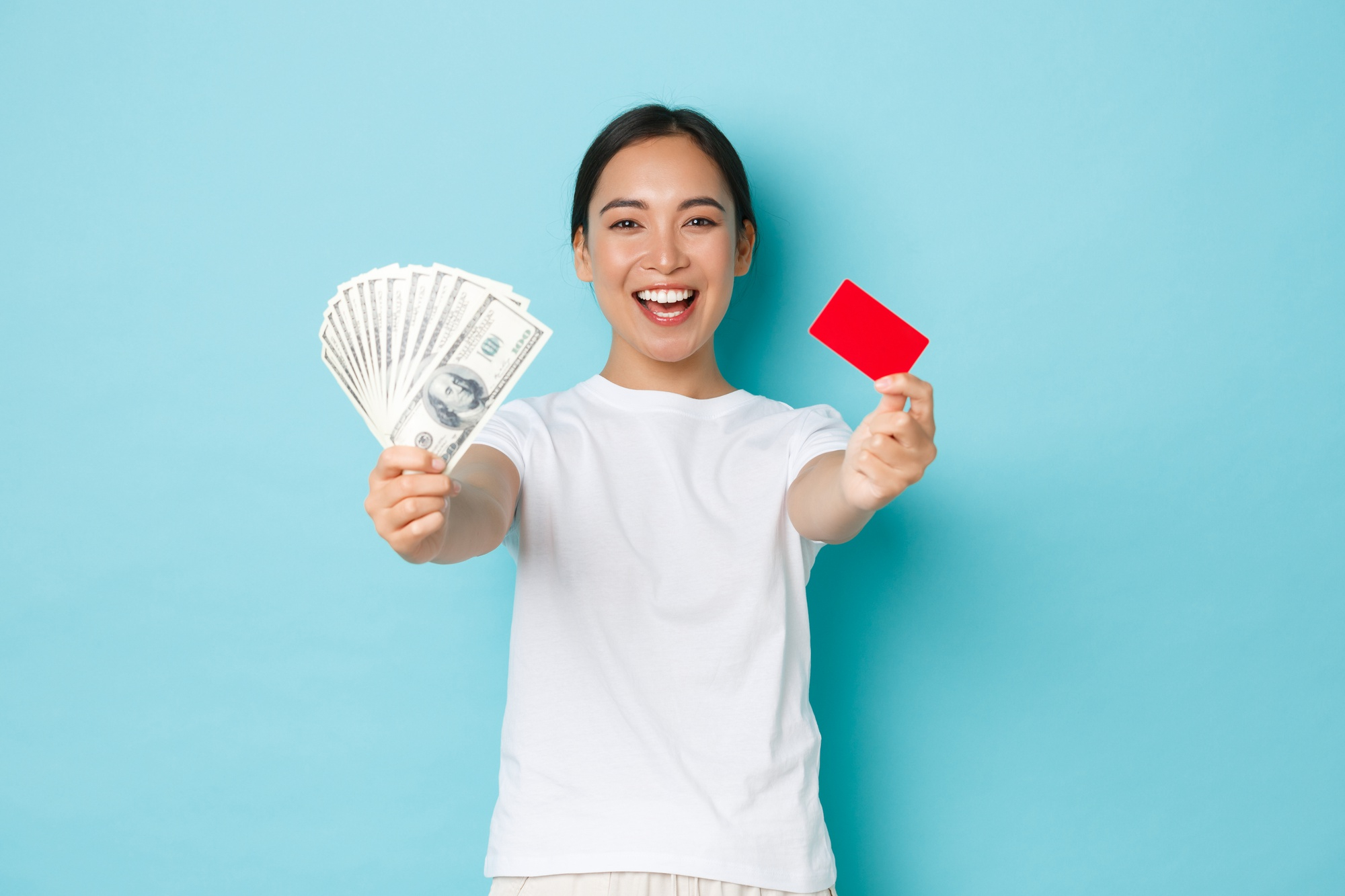 woman holding a credit card and money