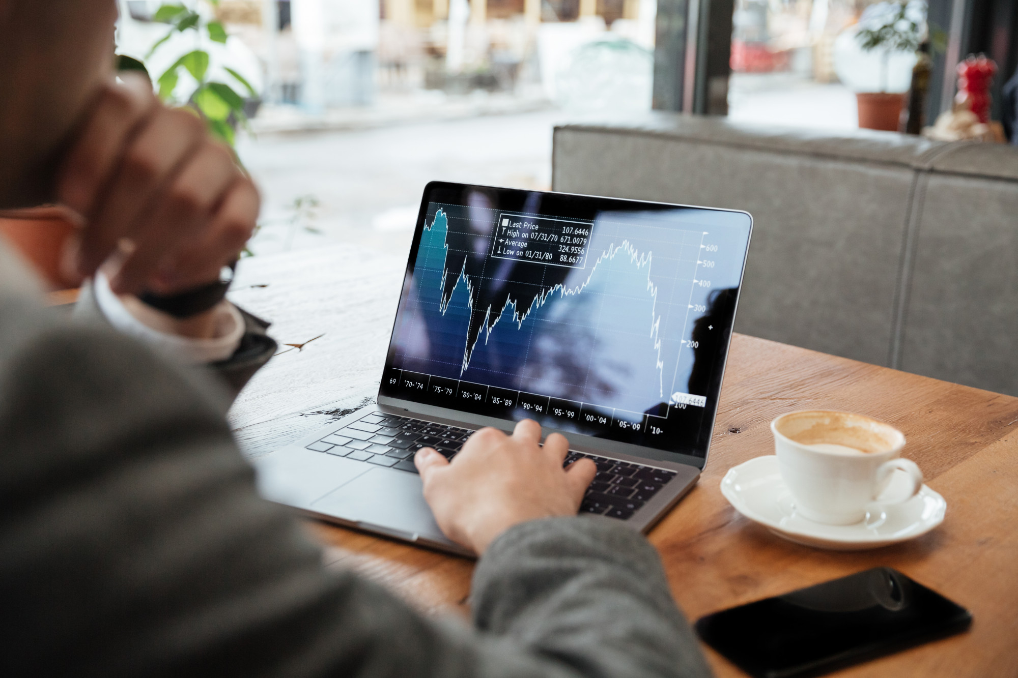 businessman sitting by table cafe analyzing indicators