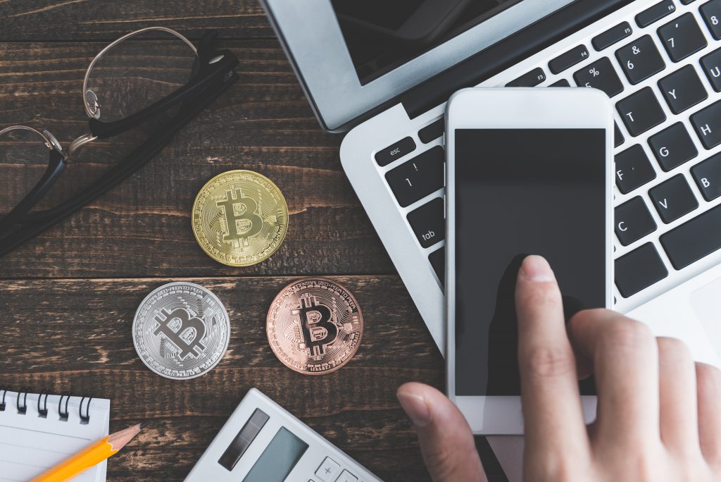 bitcoin and computer on wooden table