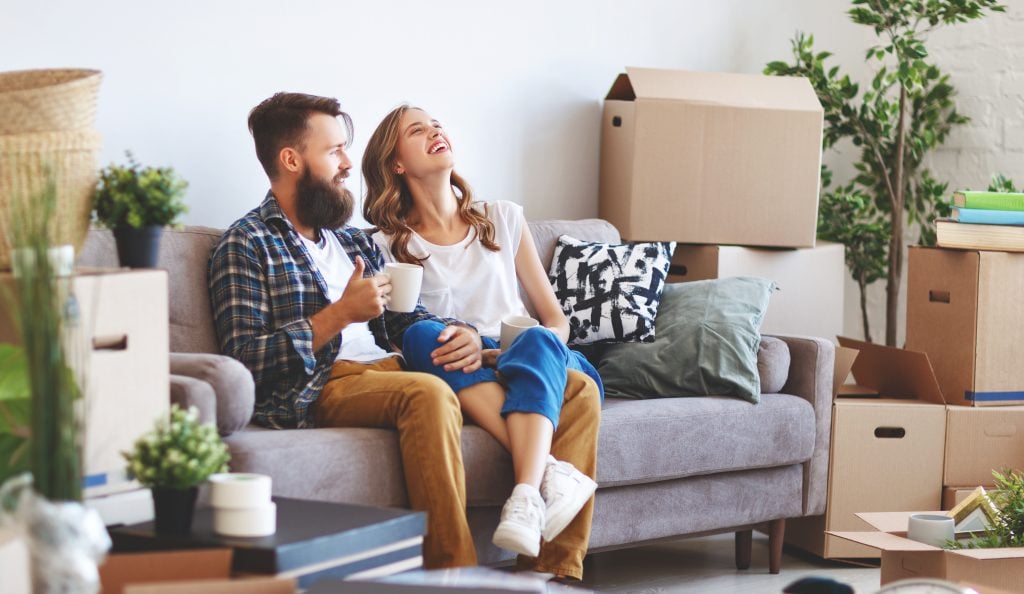 happy young married couple moves to new apartment