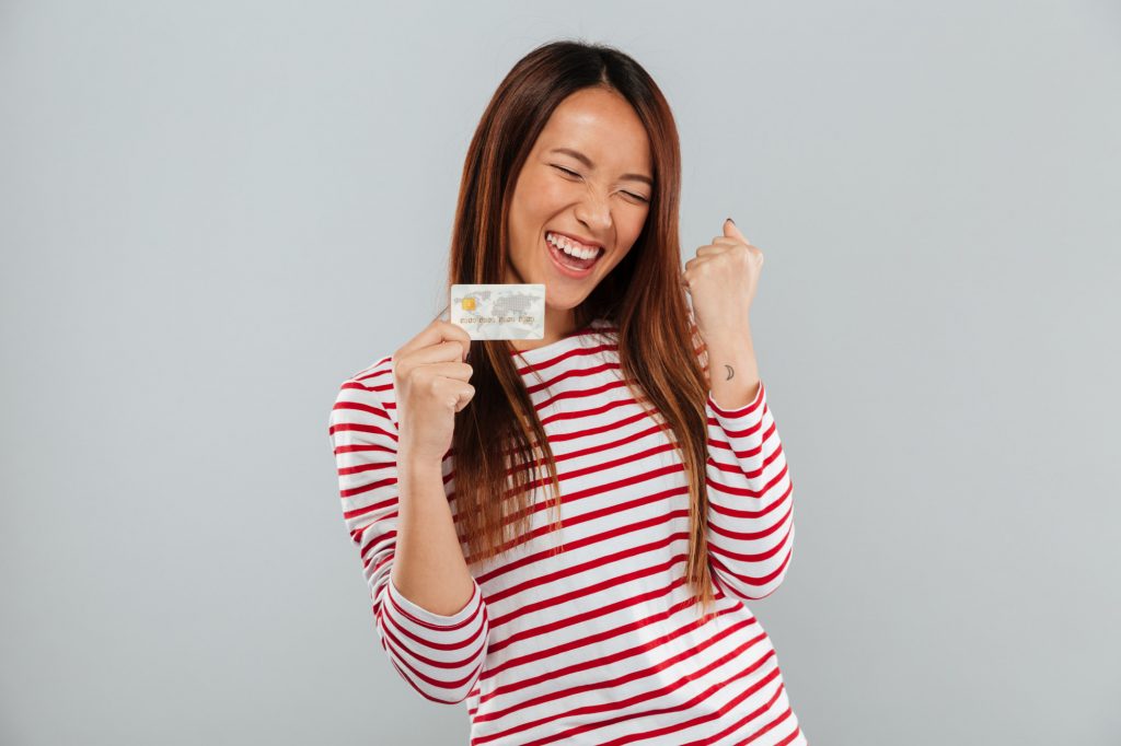 happy woman celebrating with credit card