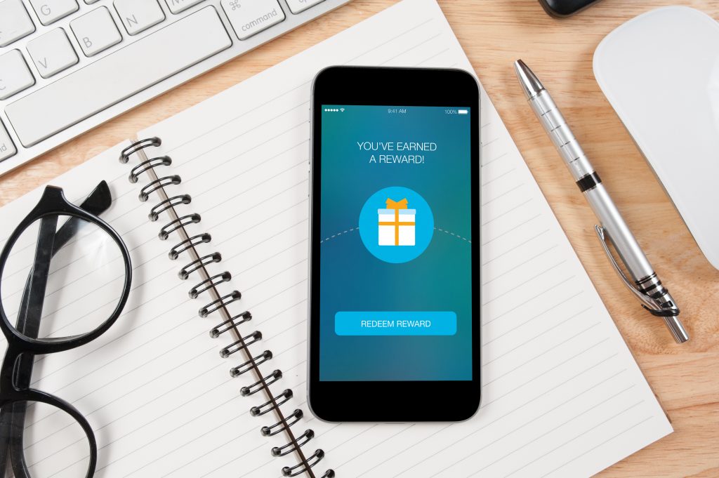 Concept mobile reward screen with office supplies on the table