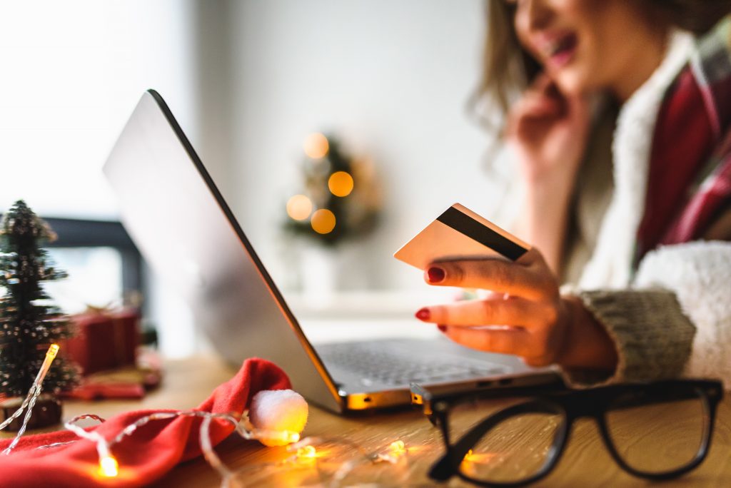 Young woman buying online at home  for winter holidays using lap
