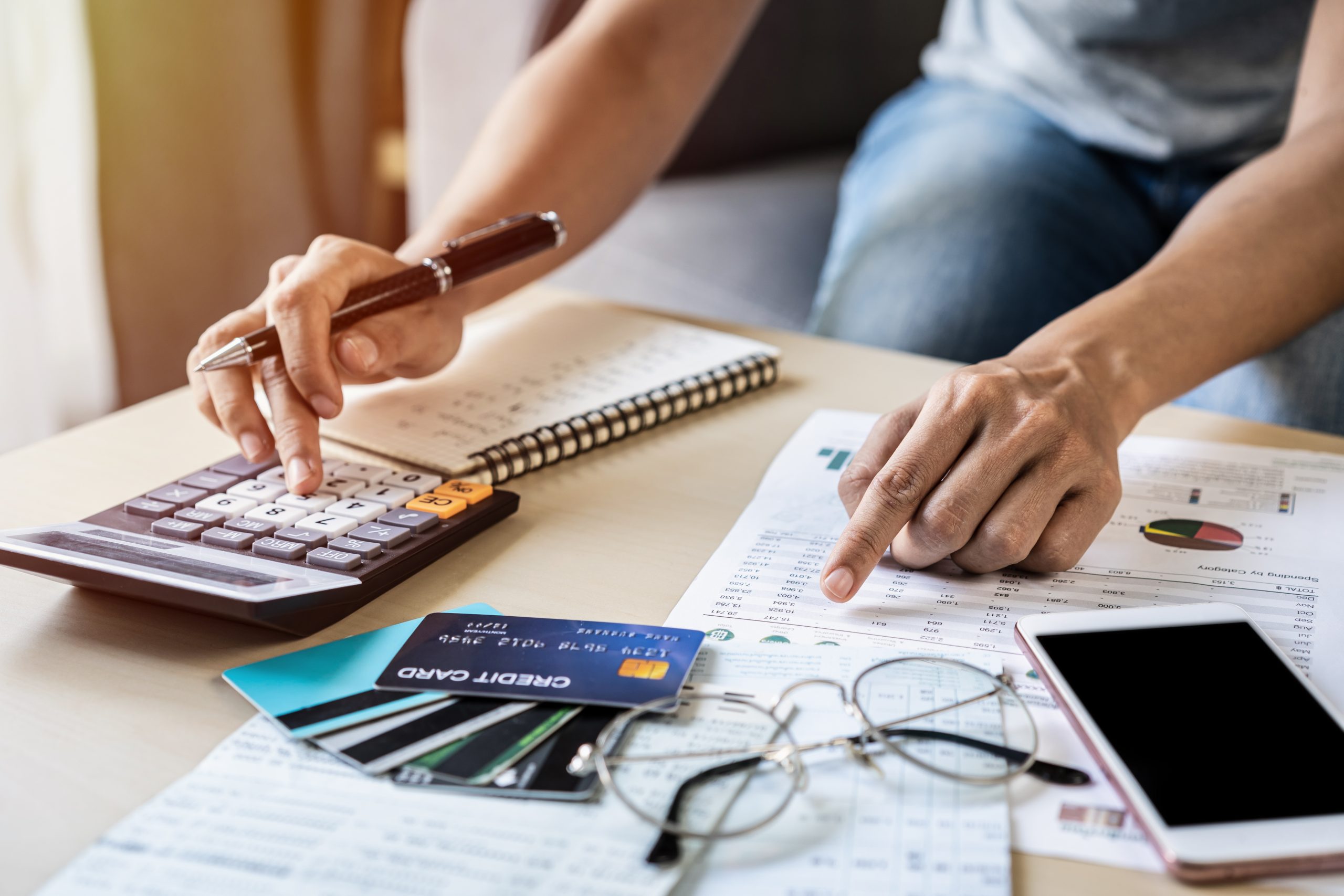 Young woman checking bills, taxes, bank account balance and calculating credit card expenses at home