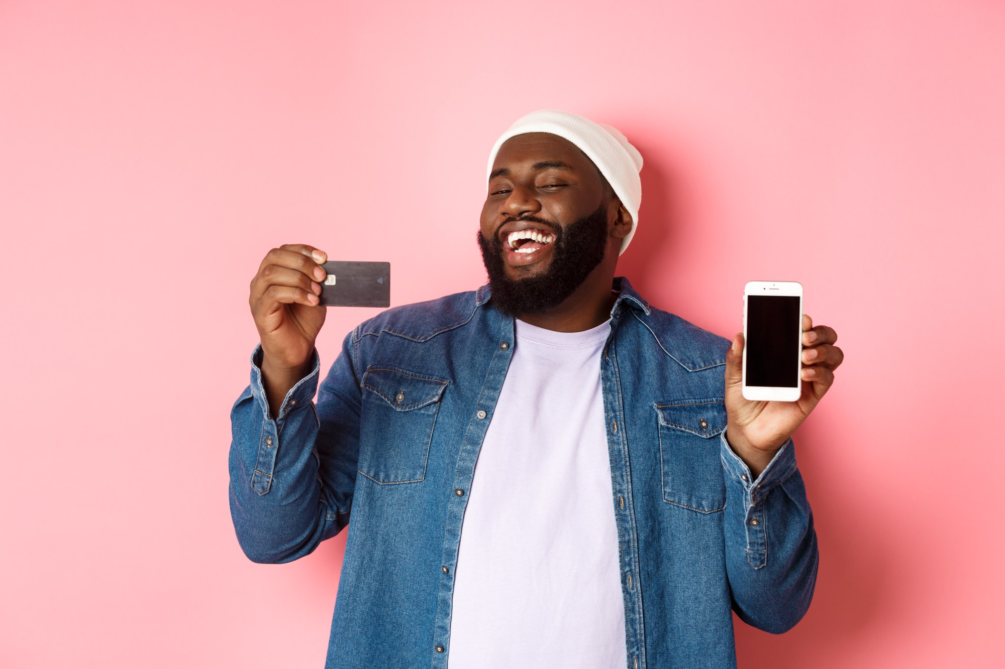 happy man holding credit card and cell phone smiling