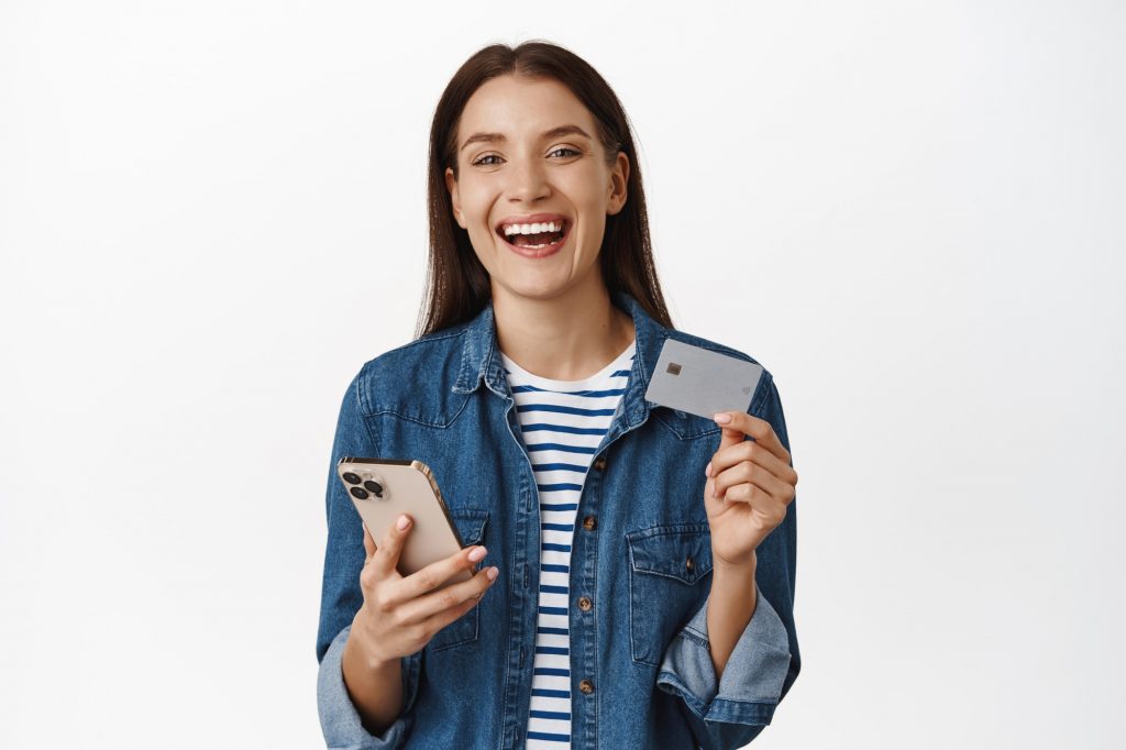 young woman smiling holding credit card