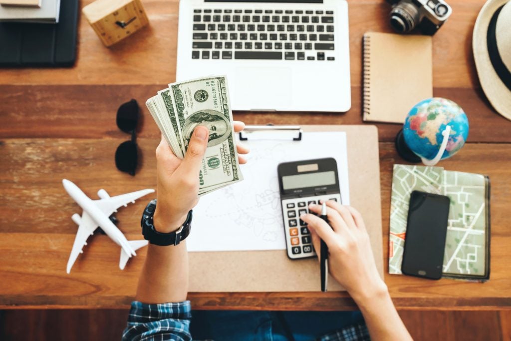 Top view tourist counting cash to spend during his luxury vacation, planning budget