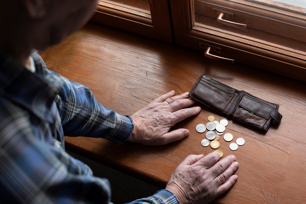 Hands of an old man and counting money, coins. The concept of po