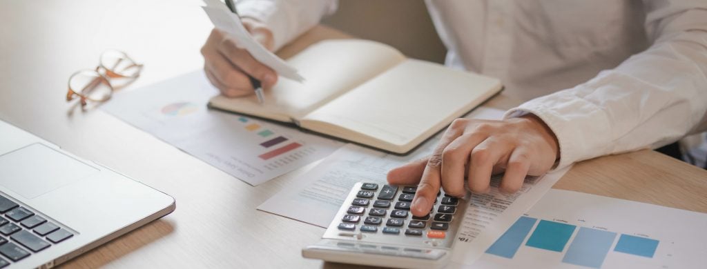 Close up hand of stress young asian businessman,male is pressing a calculator to calculate tax income and expenses, bills, credit card for payment or payday at home, office.Financial, finance concept.