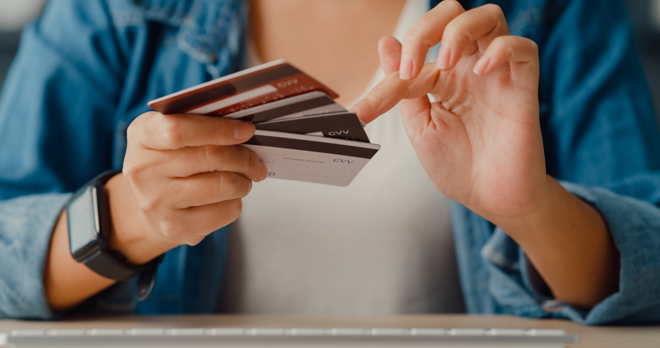 Young asia lady using computer order online shopping product and paying bill with credit card in living room interior. Stay at house, Self quarantine activity, Fun activity for coronavirus prevention.