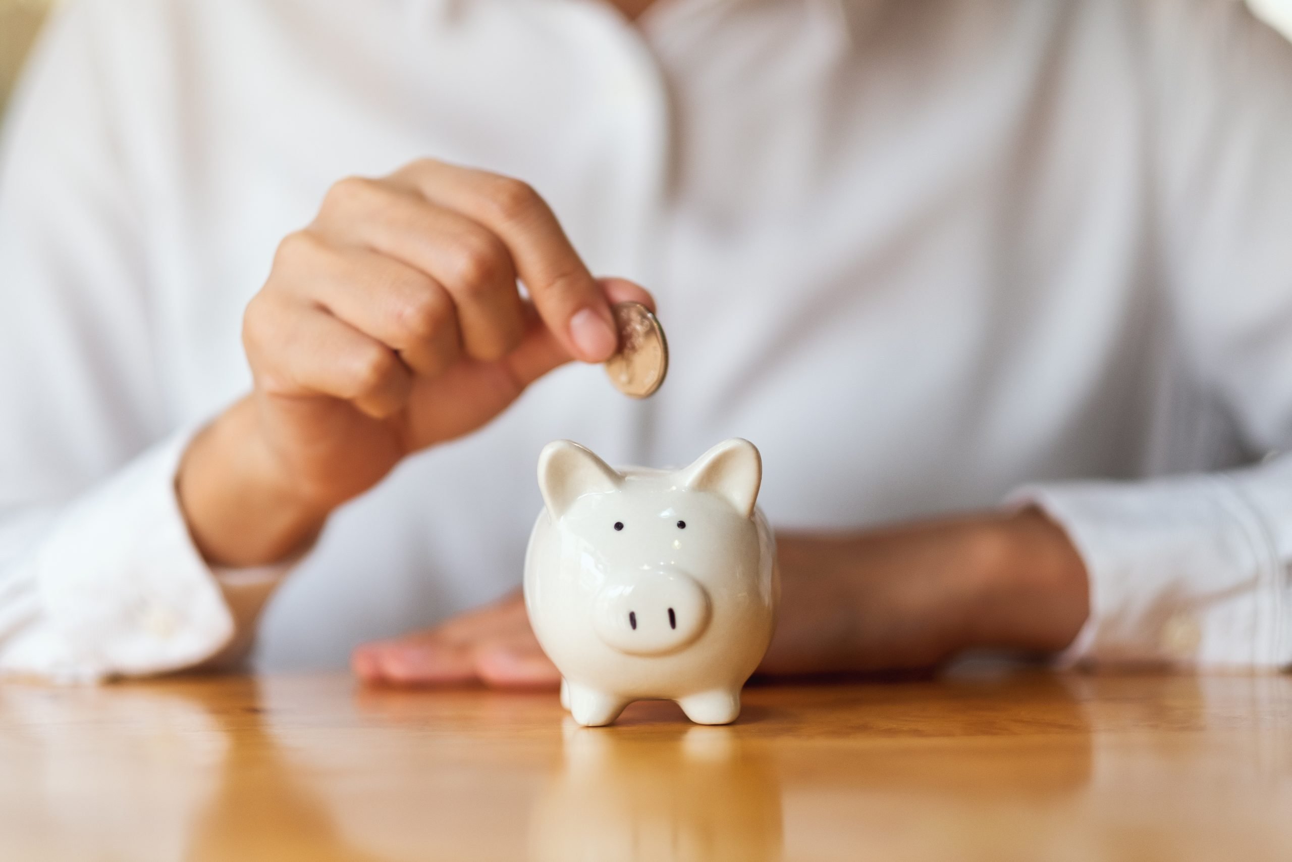 A woman putting coins into piggy bank for saving money concept