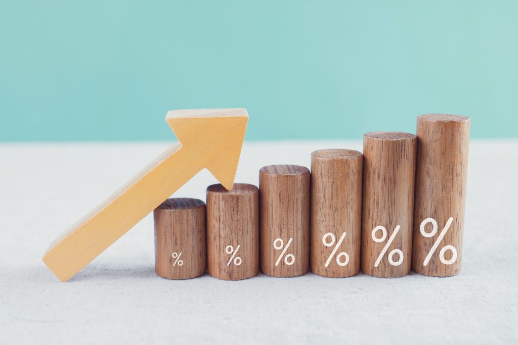 Wooden blocks with percentage sign and arrow up, financial growt