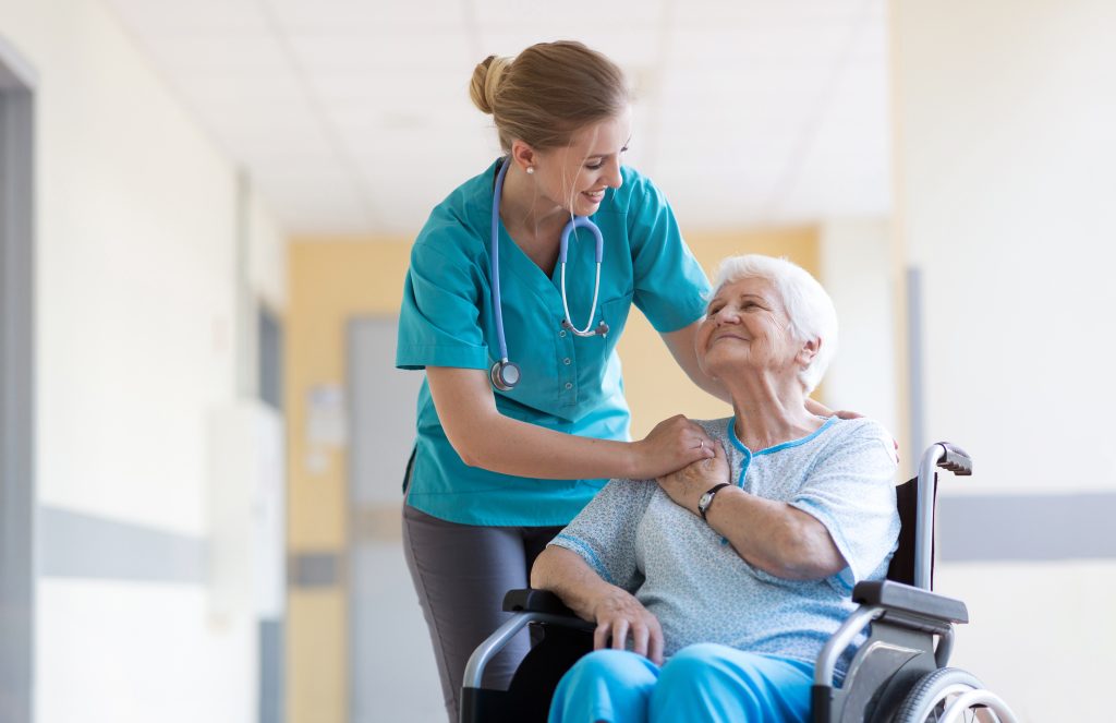 Senior woman in wheelchair with nurse in hospital