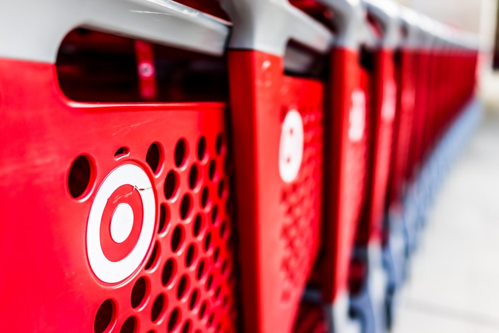 Many rows of red shopping carts outside by store with closeup by Target store parking lot