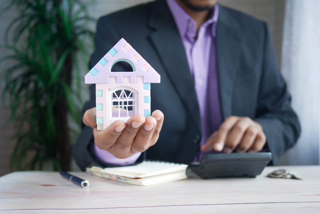 male hand holding a house miniature