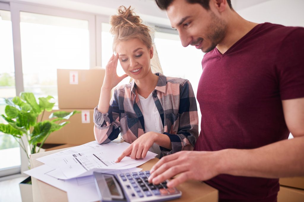 Worried couple examining expenses after moving into new house