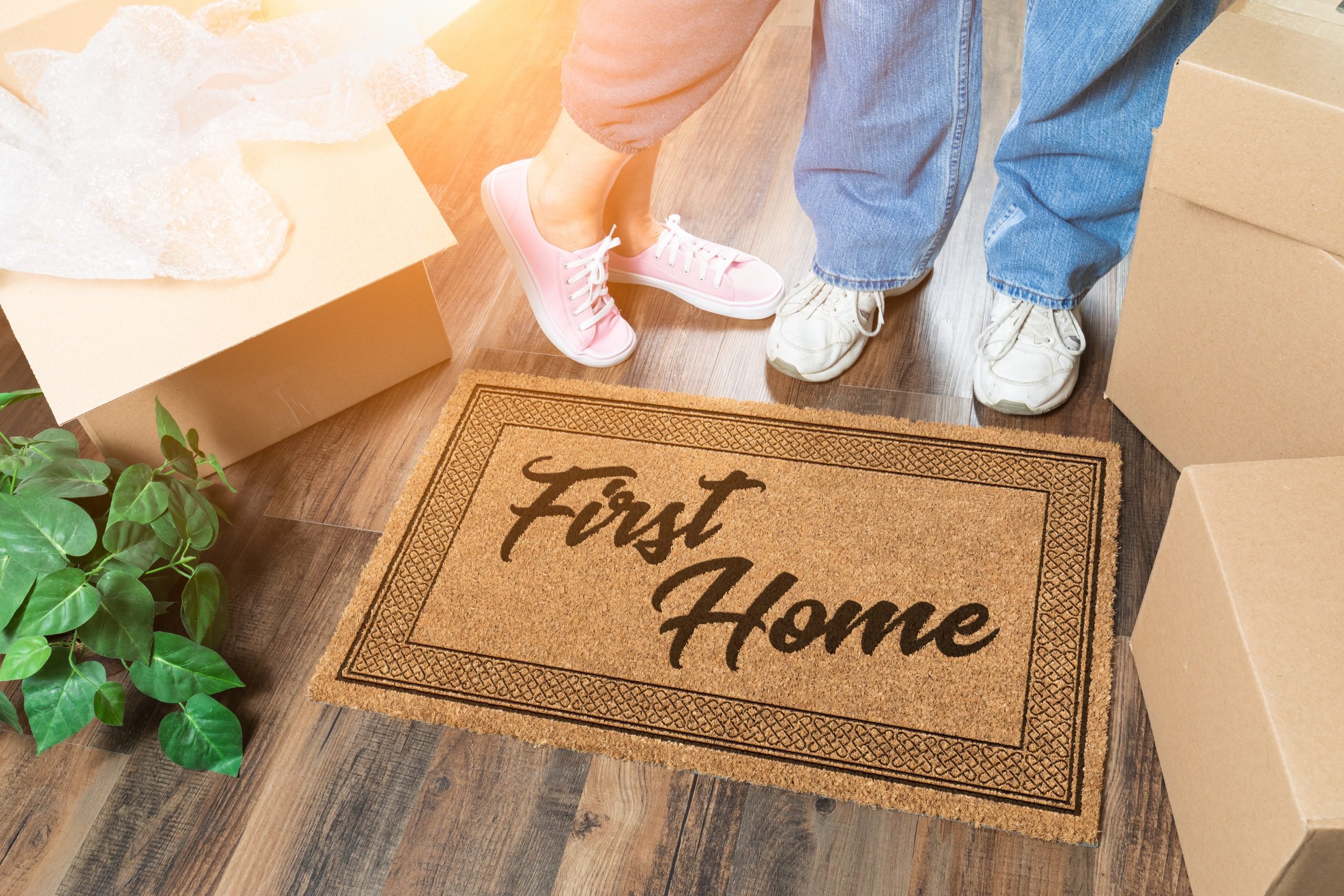 home; welcome; welcome mat; mat; house; new; wood; floor; floor mat; real estate; real; estate; door mat; greeting; matt; object; sign; brown; doormat; boxes; moving; new home; new house; unpacking; moving boxes; moving in; couple; people; feet; man; woman; male; female; standing; married; lifestyle, first home, first house, first time buyer, home, shoes