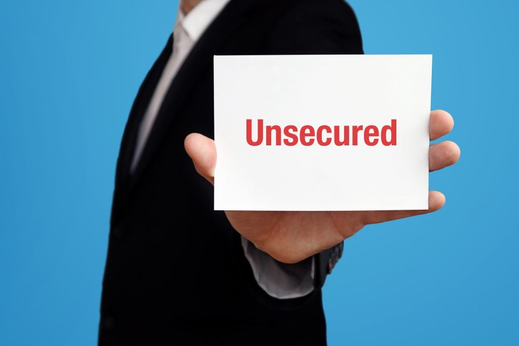 Unsecured. Business man in a suit holds card at camera. The term