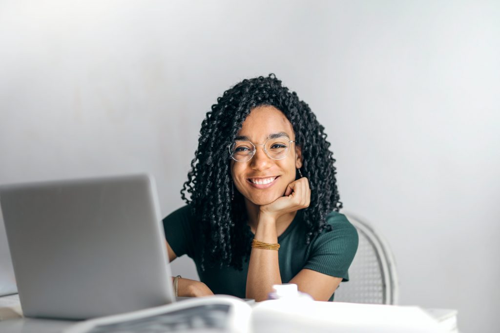 young woman smilling in front of her laptop