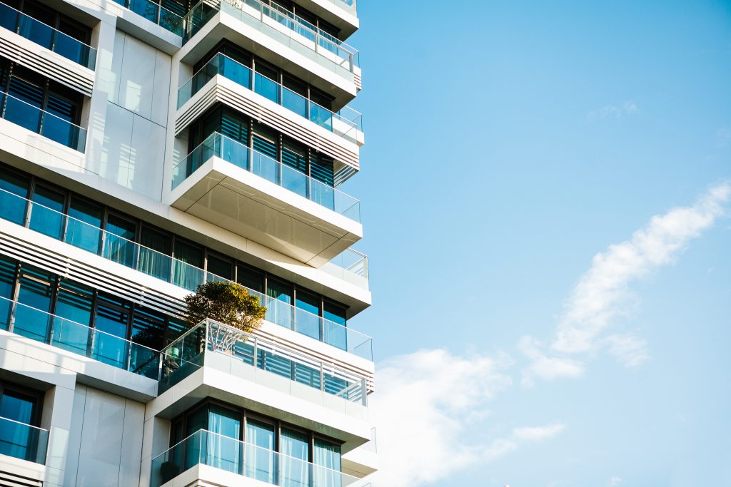 The corner of the building with many windows against the blue sky