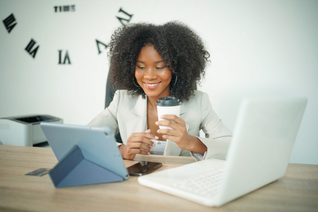 Happy woman holding credit card to do shopping online on computer and smiling.