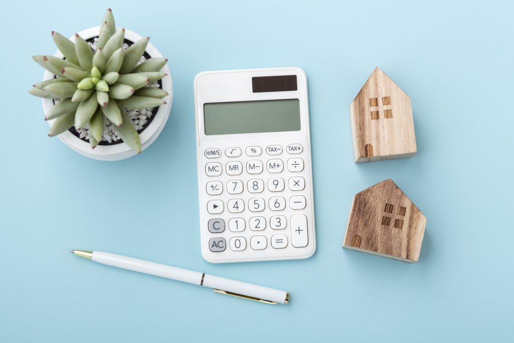 Calculator with house model, home loan or mortgage concept