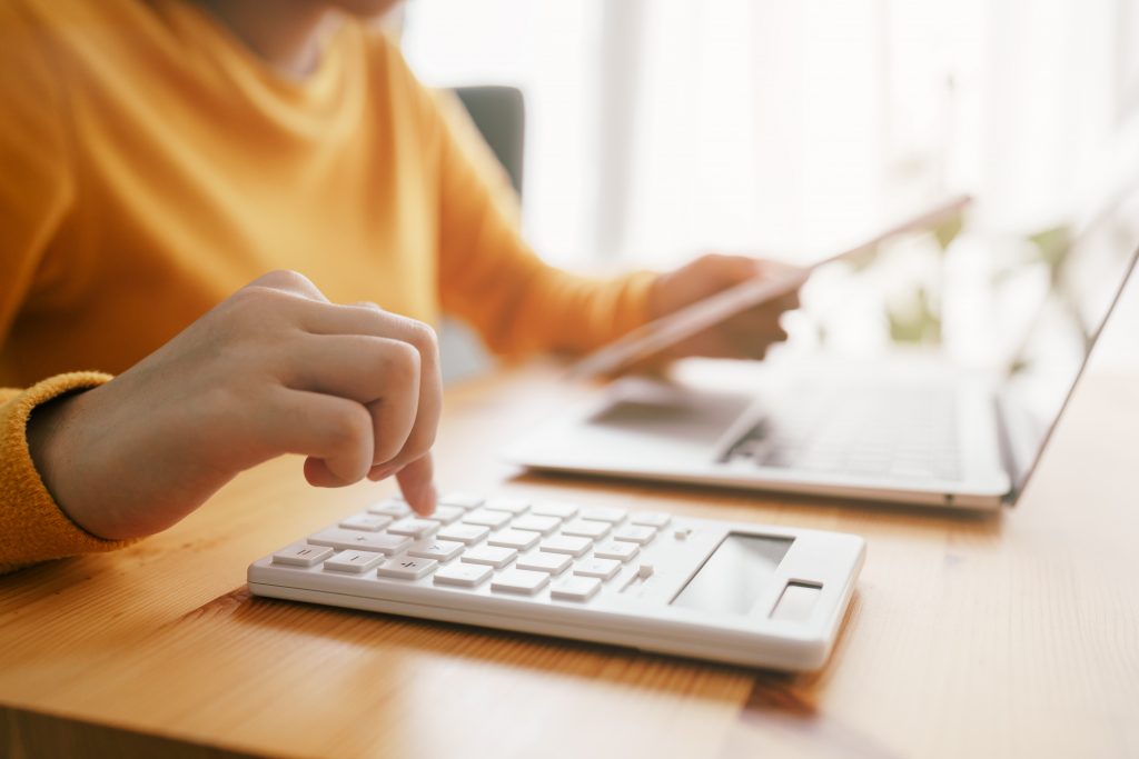 Hand of Asian woman are calculating costs and payment checking a