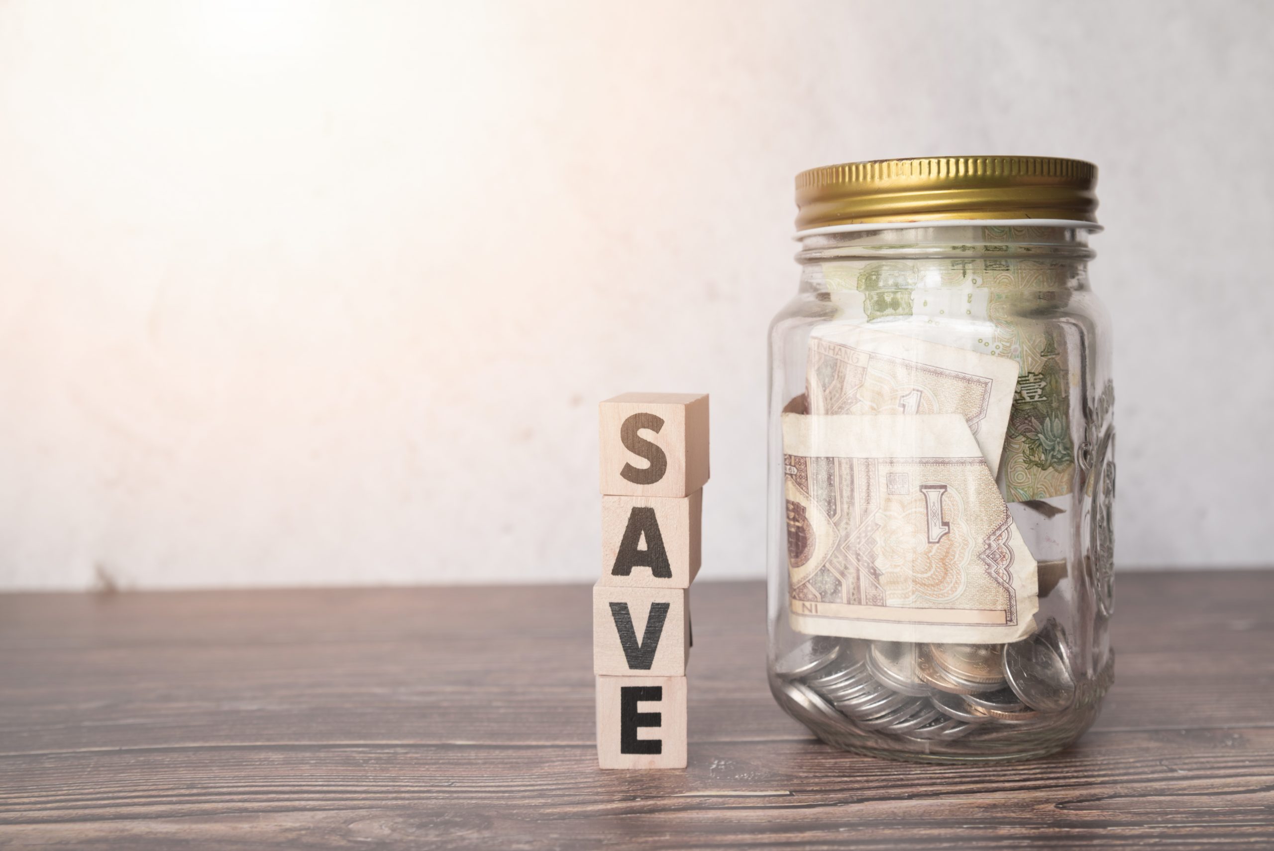 glass-jar-savings-with-wooden-word