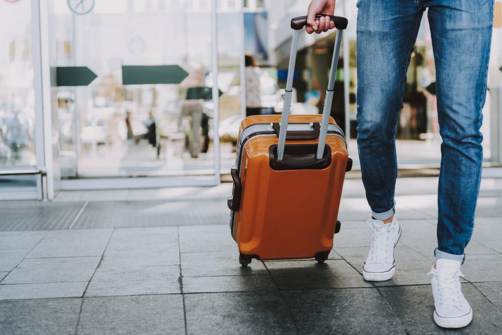 Male is carrying luggage in hall before trip