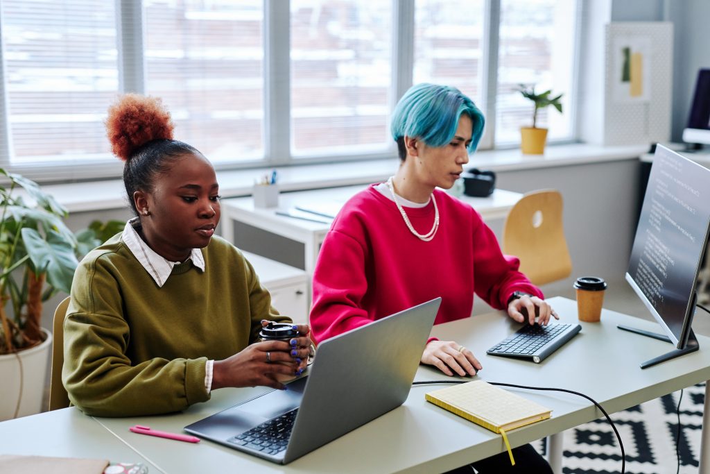 Two gen Z young people using computers developing software and writing code