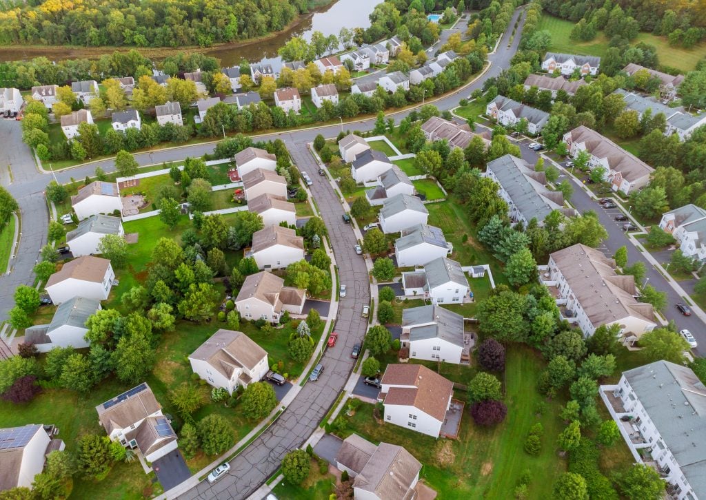 Aerial view over suburban homes and roads early sunrise