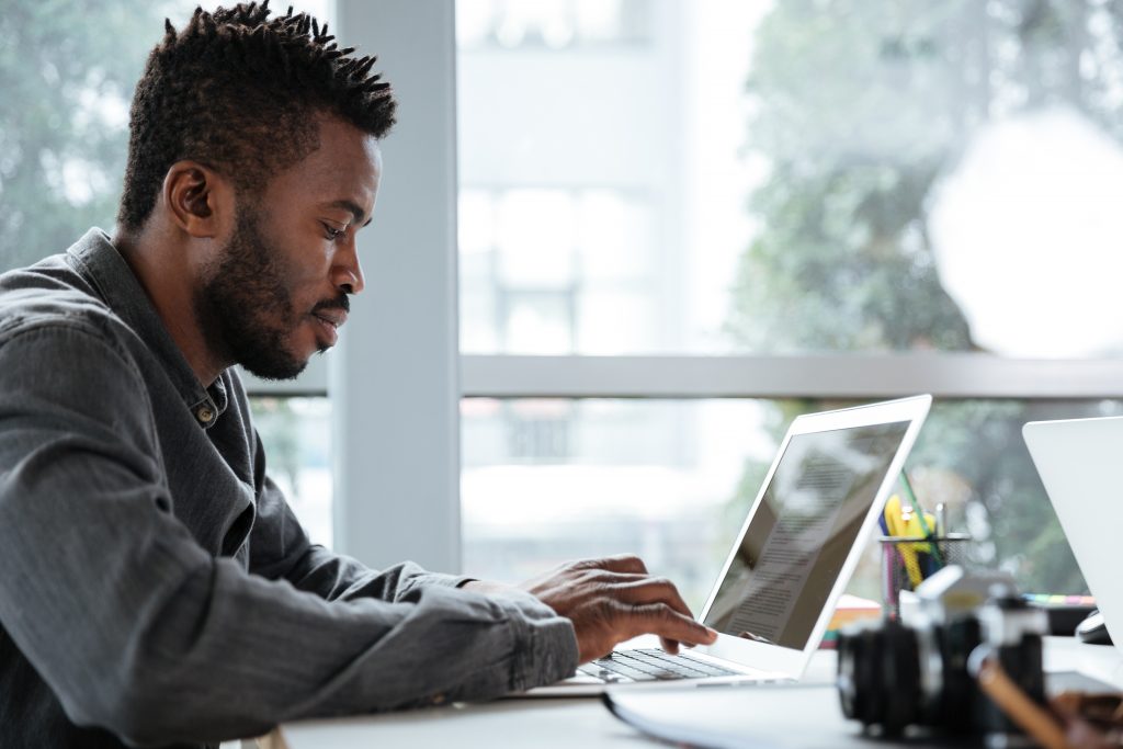 Handsome thinking serious young man sitting in office coworking