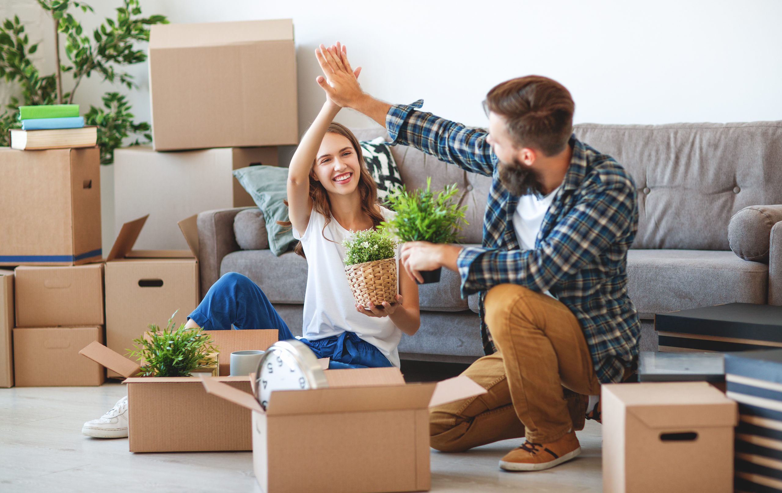 happy young married couple moves to new apartment