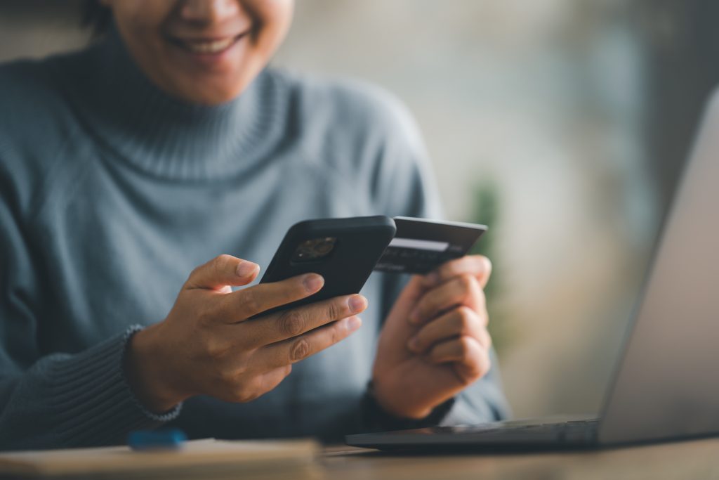woman makes a purchase on the Internet on the smart phone with credit card, online payment, shopping online, e-commerce, internet banking, spending money