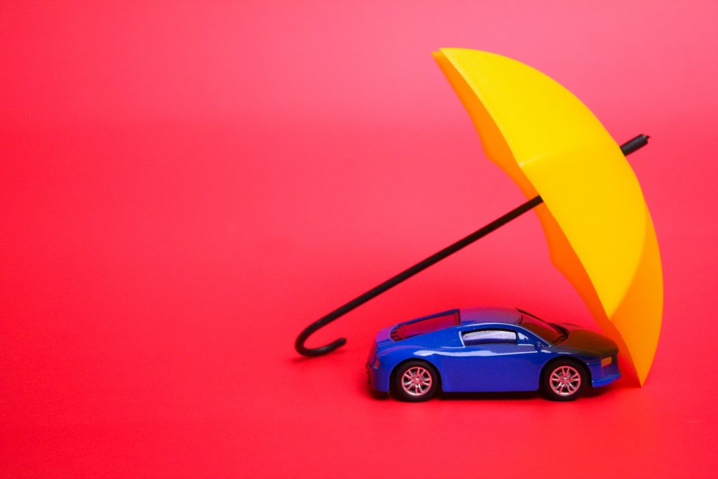 an umbrella protects the car. vehicle insurance concept. Car ins