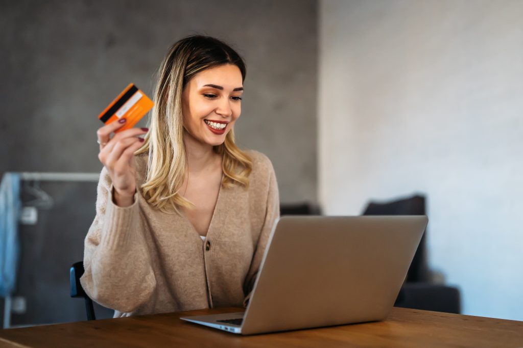 Technology people online shopping concept. Happy smiling woman with laptop computer and credit card