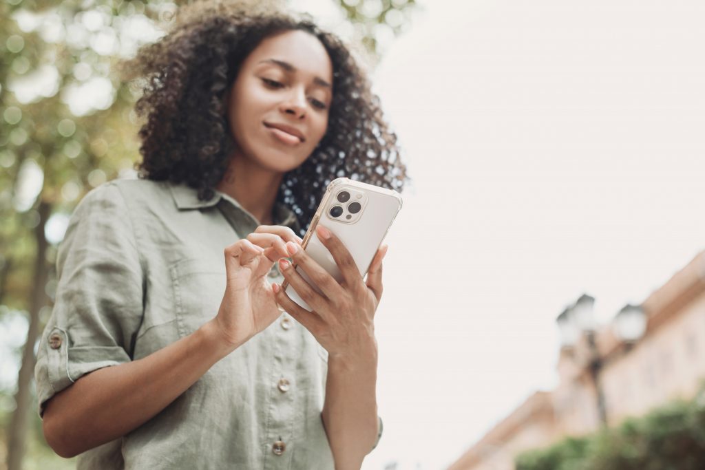 Young beautiful woman using smartphone in a city. Smiling studen