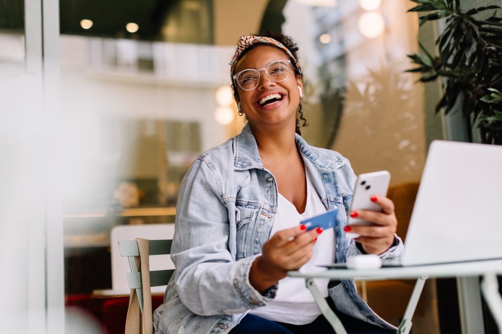 Young woman using smartphone for online shopping in a coffee shop