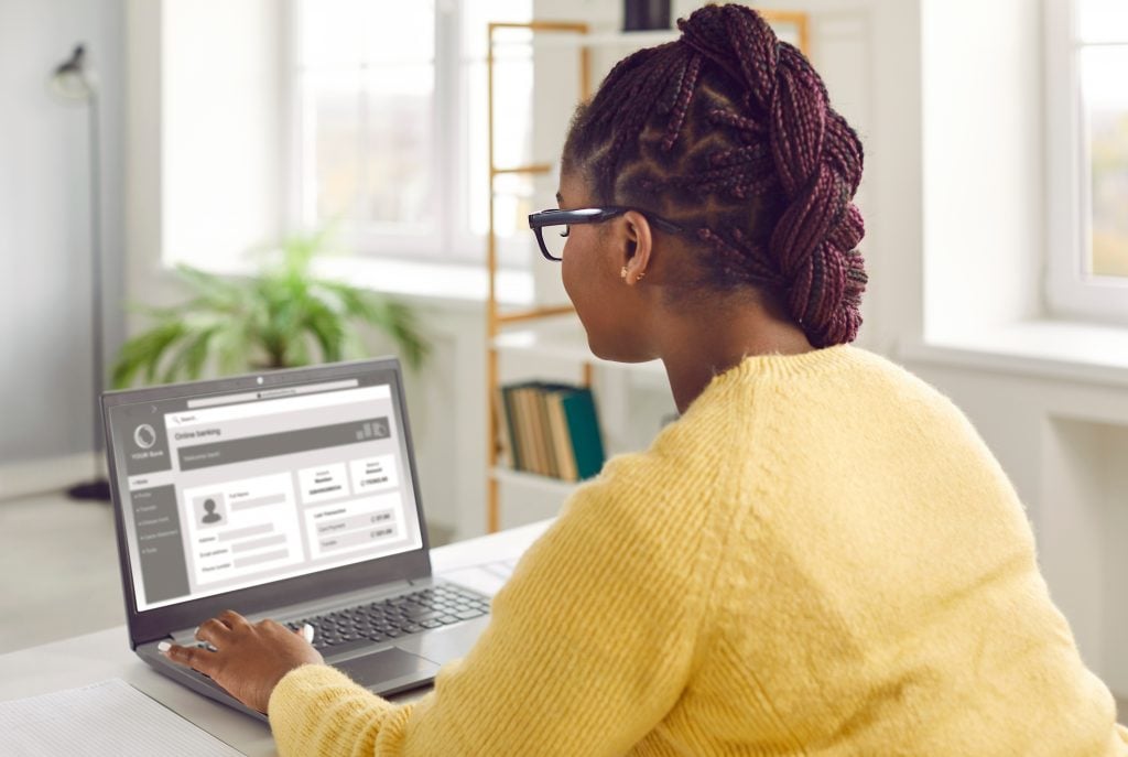 African American woman using modern online banking website on her laptop computer